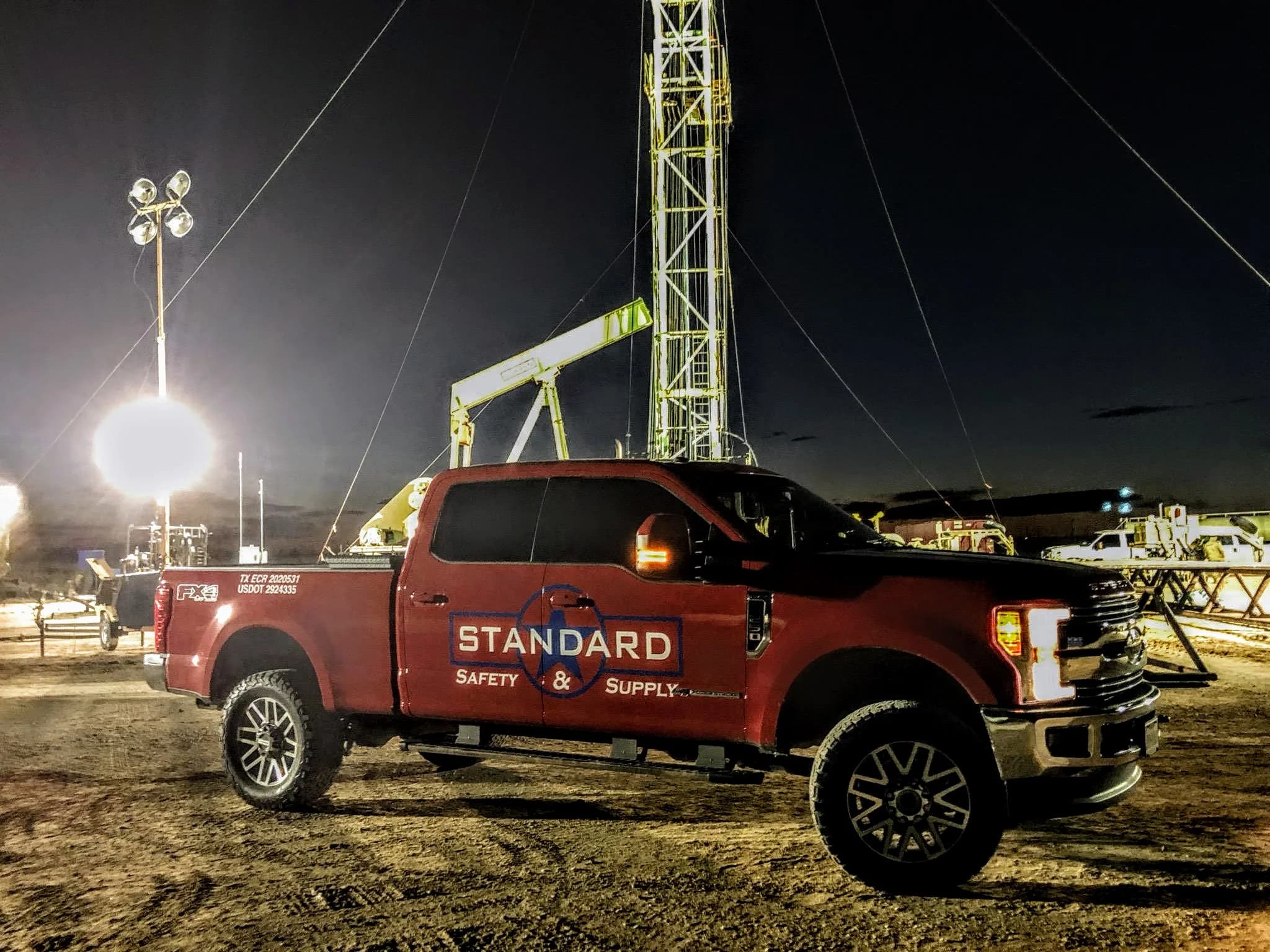 Standard Safety truck at a drilling rig site at night